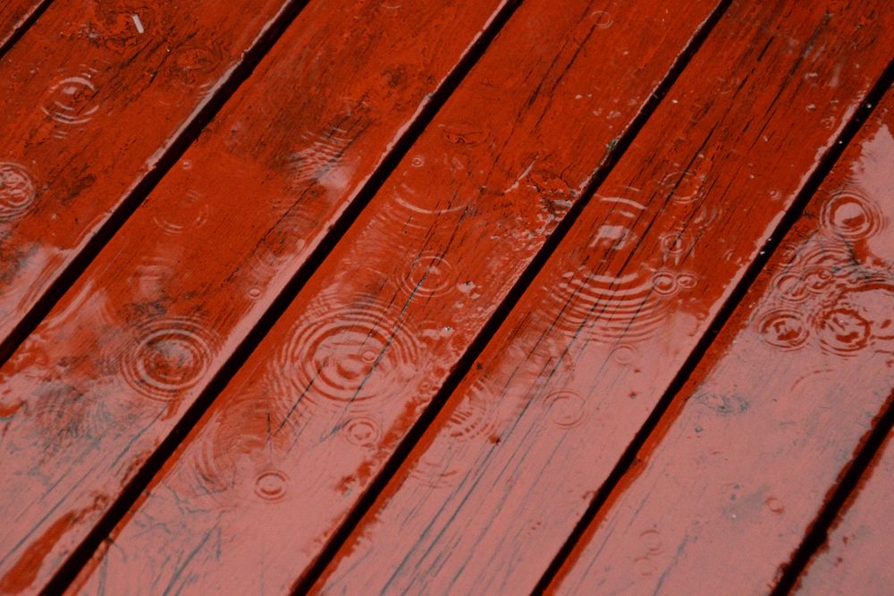 Rain beading on a sealed, red-stained deck