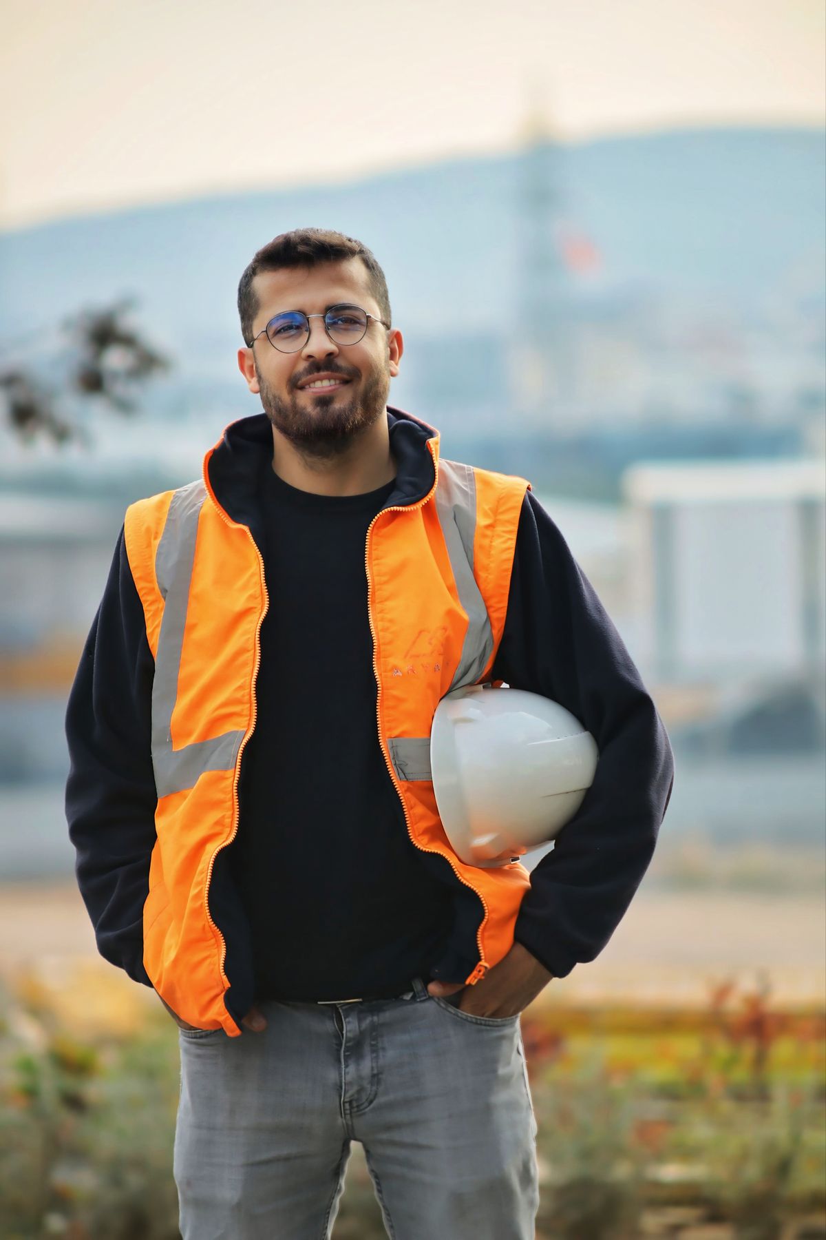 Hauloff founder smiling in a safety vest, holding a hard hat