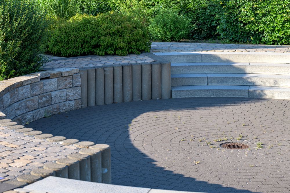Curved paver patio with a segmental retaining wall and wide stone steps