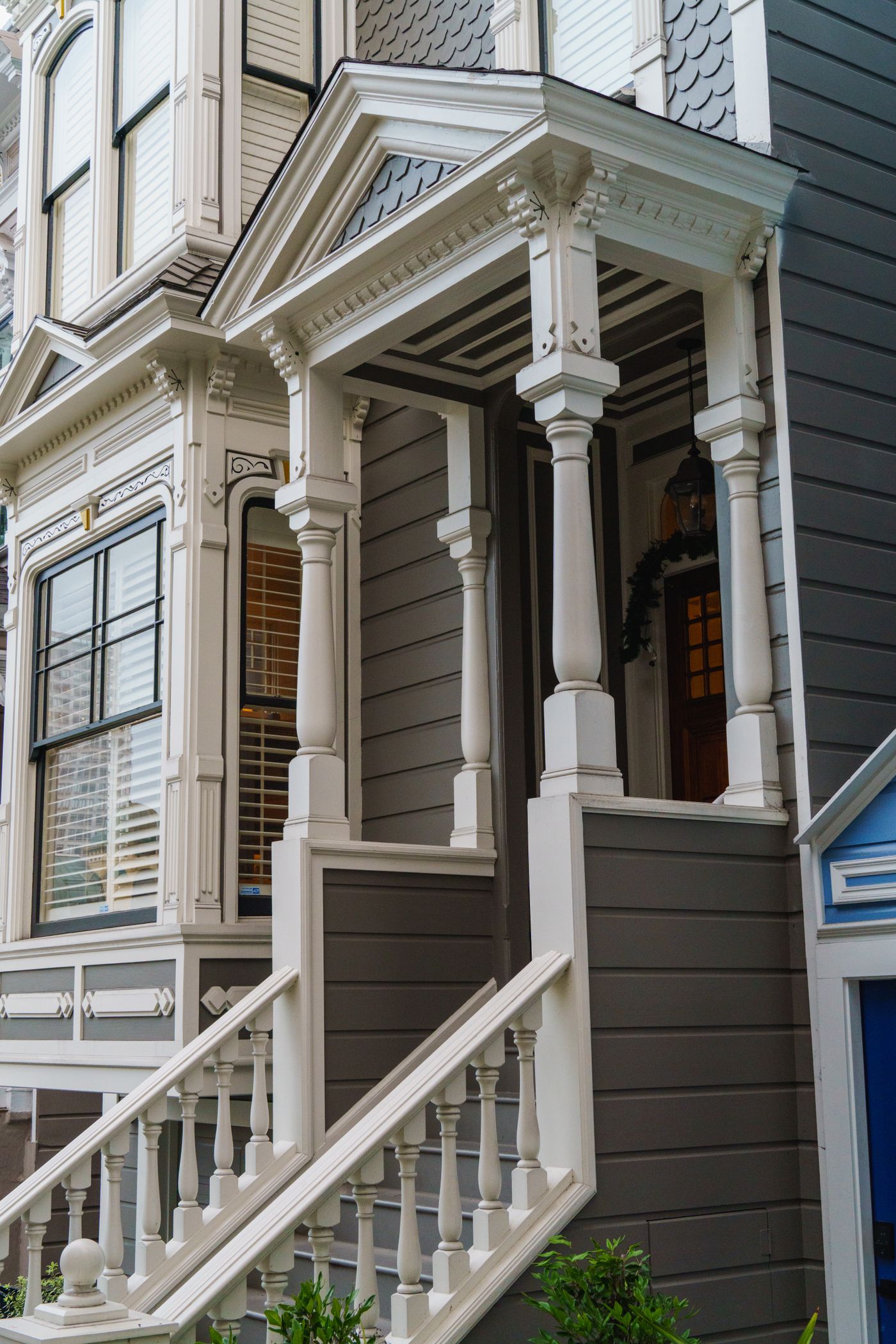 Victorian porch painted soft gray with crisp white trim