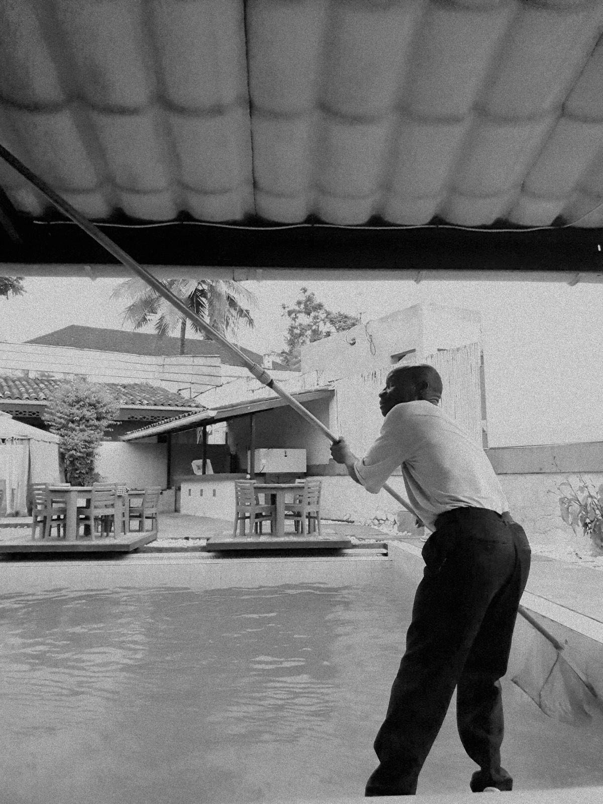 Mario skimming a pool with a long telescoping pole