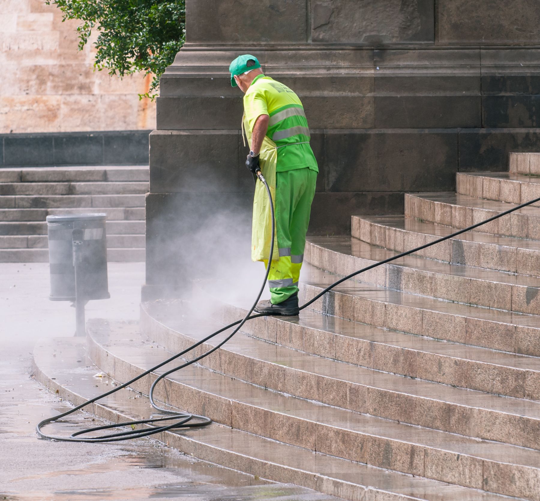 Worker pressure washing wide stone steps