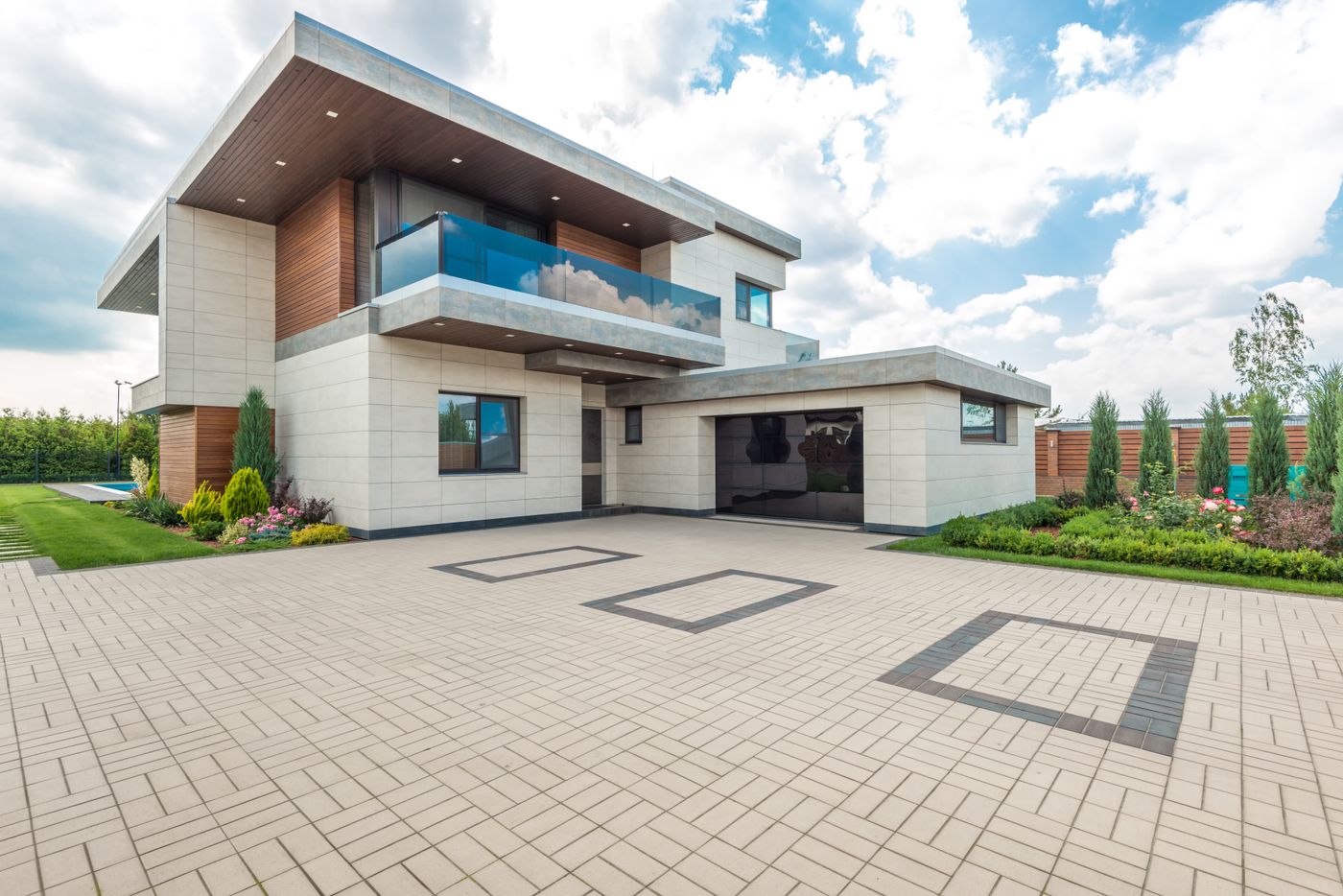 Modern home with a spotless light paver driveway