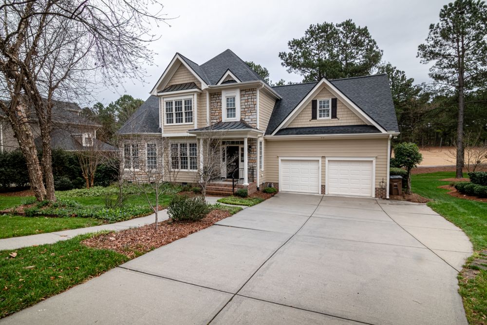 Two-story home with a bright, clean concrete driveway