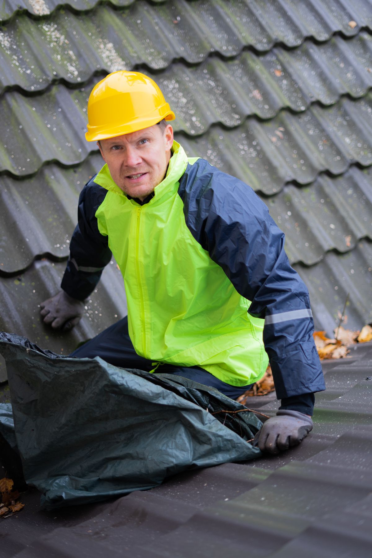 Front Range roofer in a hard hat on a tile roof